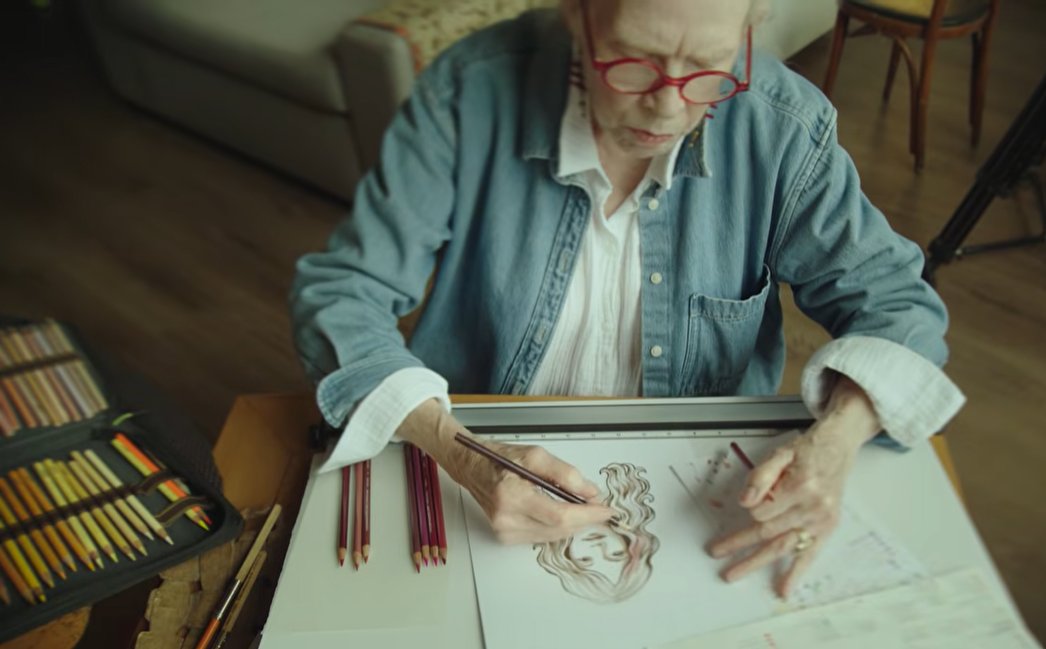 Artist Claudia Hammer at her drawing table, working on the original can artwork